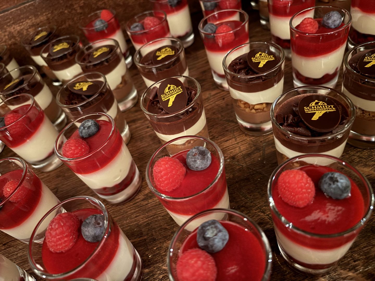 Schichtdesserts mit Beeren und Schokolade, dekoriert mit dem Schmidt-Buffetservice-Logo