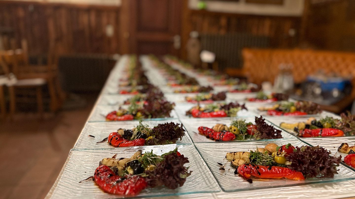 Lange Reihen von Glastellern mit Antipasti, Salat und geröstetem Gemüse