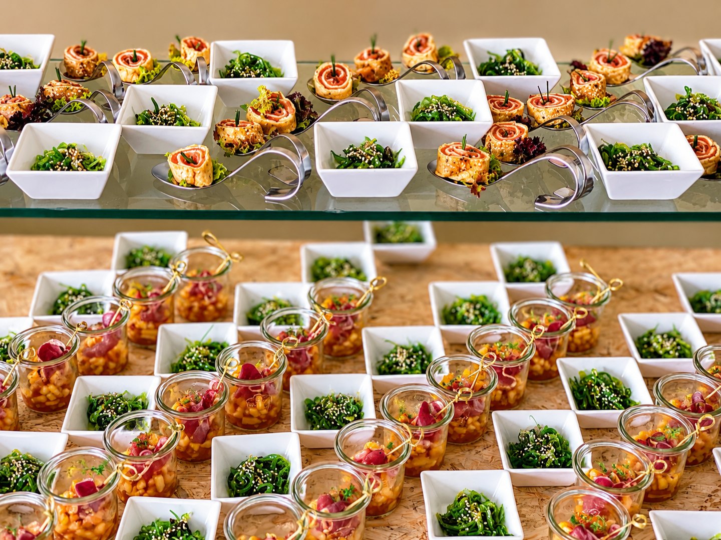 Kleine Salatschalen, Gemüsespieße und herzhaftes Gebäck auf Glasetageren