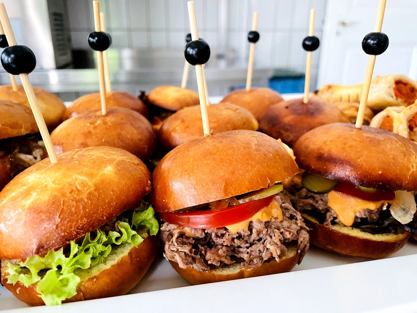 Mini-Burger mit Fleischfüllung und Salat auf einer Servierplatte
