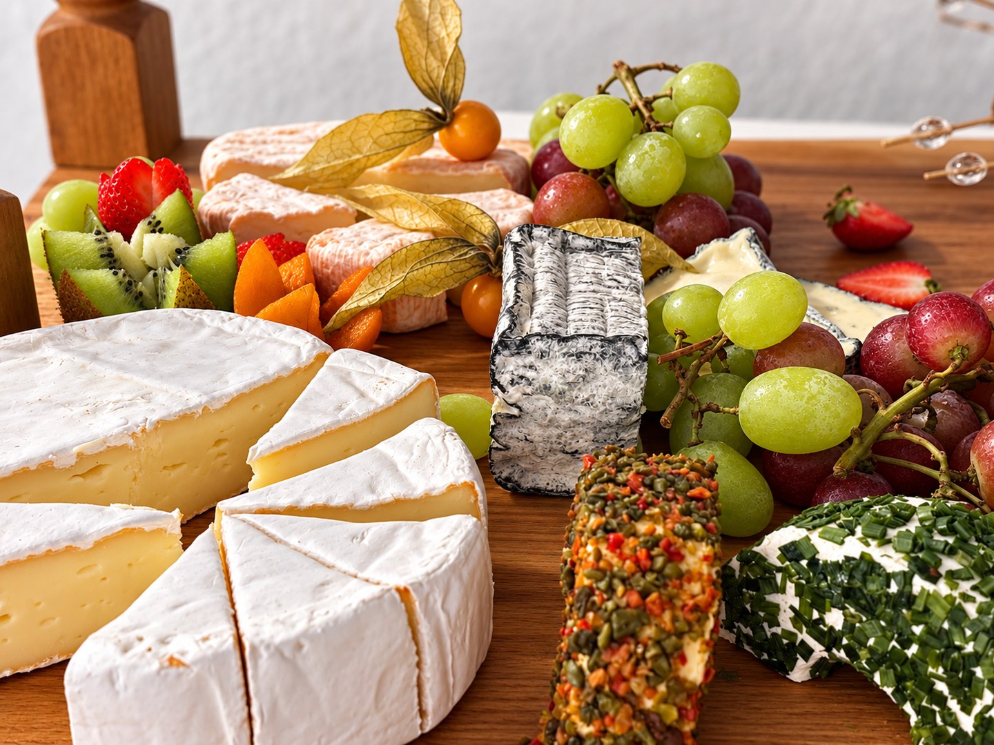 Käseauswahl mit Trauben, Erdbeeren und Kräuterfrischkäse